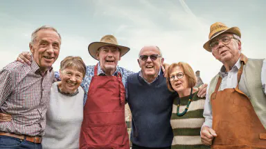 Senior friends smiling together outdoors.